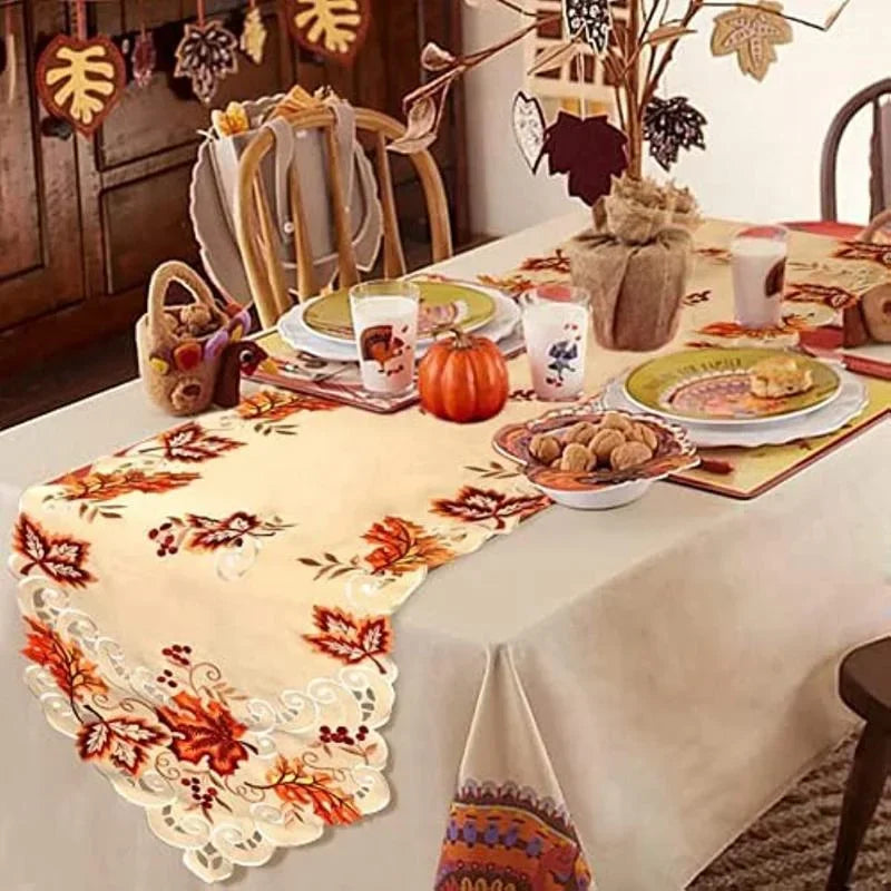 Thanksgiving table set with maple leaf embroidered fall runner, autumn dishes, and decor