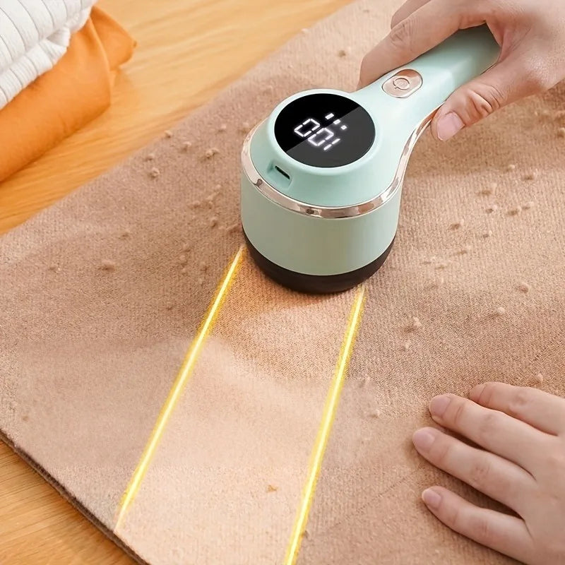 Electric lint remover with digital display being used to remove pilling from tan sweater fabric