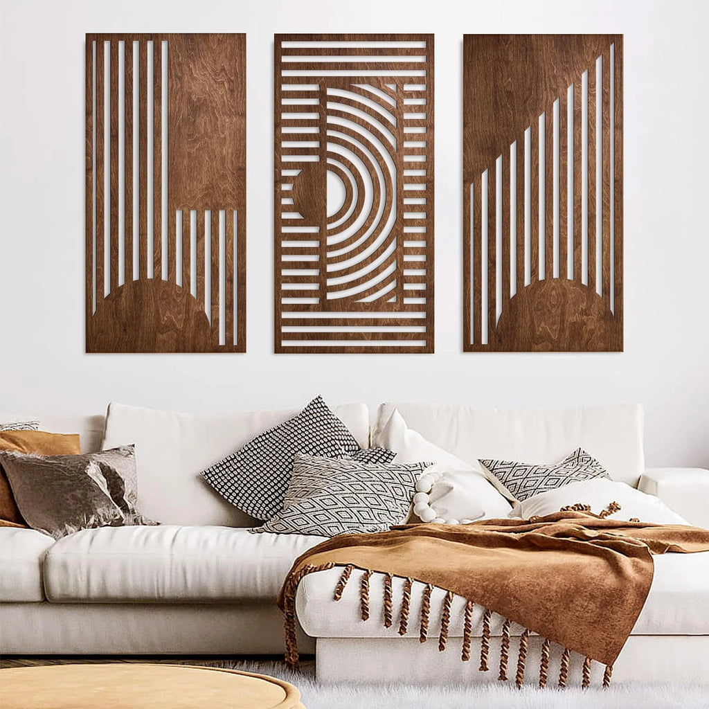 Three-piece geometric wood wall art with abstract cut-out shapes above a neutral sofa
