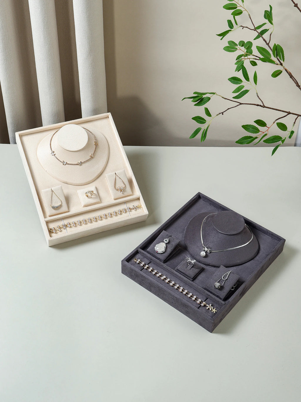 Velvet jewelry trays in beige and gray shown on a tabletop with accessories organized in compartments