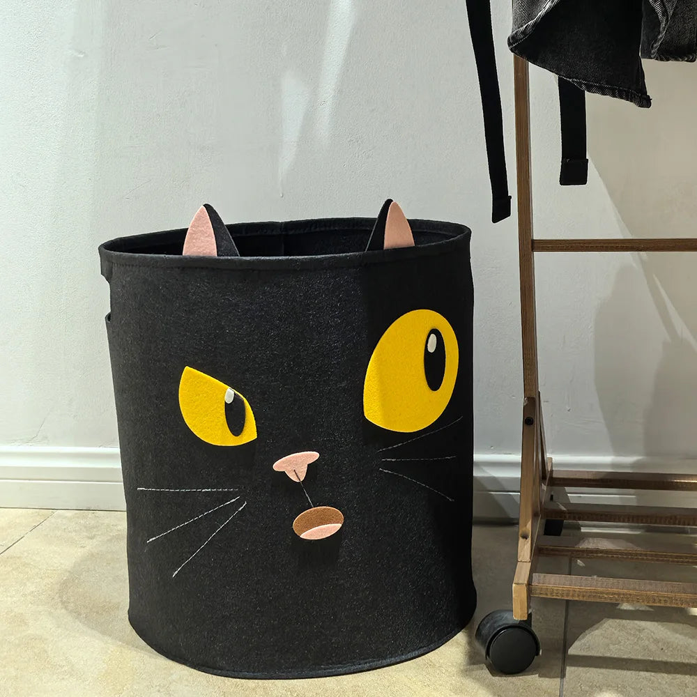 Black cat face cotton storage basket placed by laundry rack
