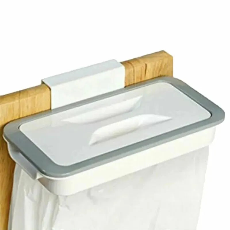 Grey and white trash bag holder shown hanging over a wooden cabinet door