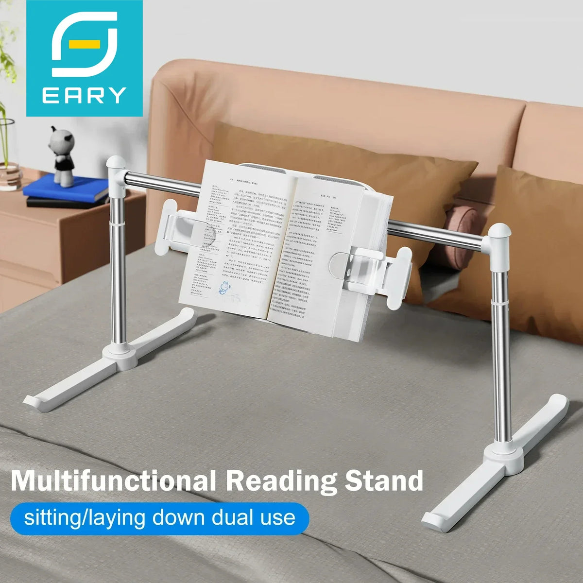 White aluminum adjustable book stand set up on a bed with a book held by page clips