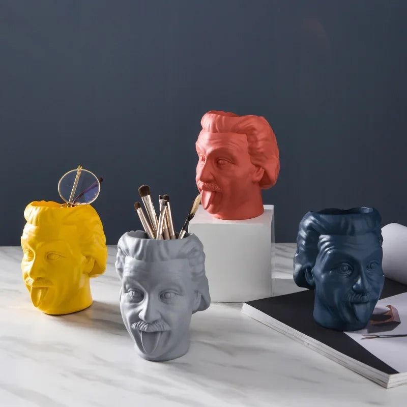 Closeup of yellow and gray head vases used for organizing pens and brushes on a marble surface
