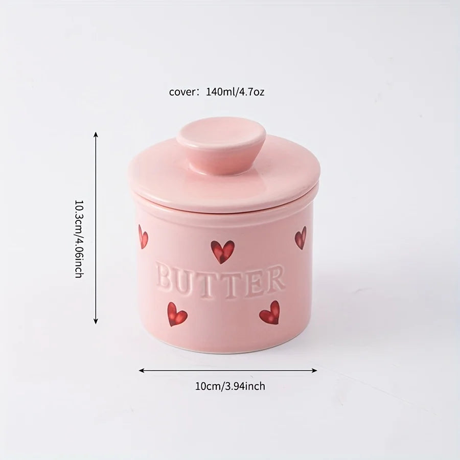 Pink heart-decorated ceramic butter crock with lid; dimensions labeled as 10.3 cm high, 10 cm wide.
