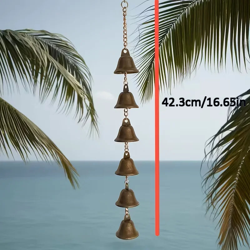Rustic iron wind chime with six bells, annotated length of 42.3 cm, hanging by palm trees and ocean