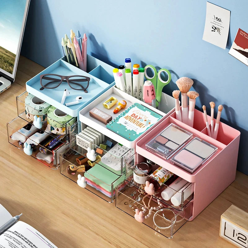 Three desk organizers in blue, white, and pink, arranged side by side with supplies