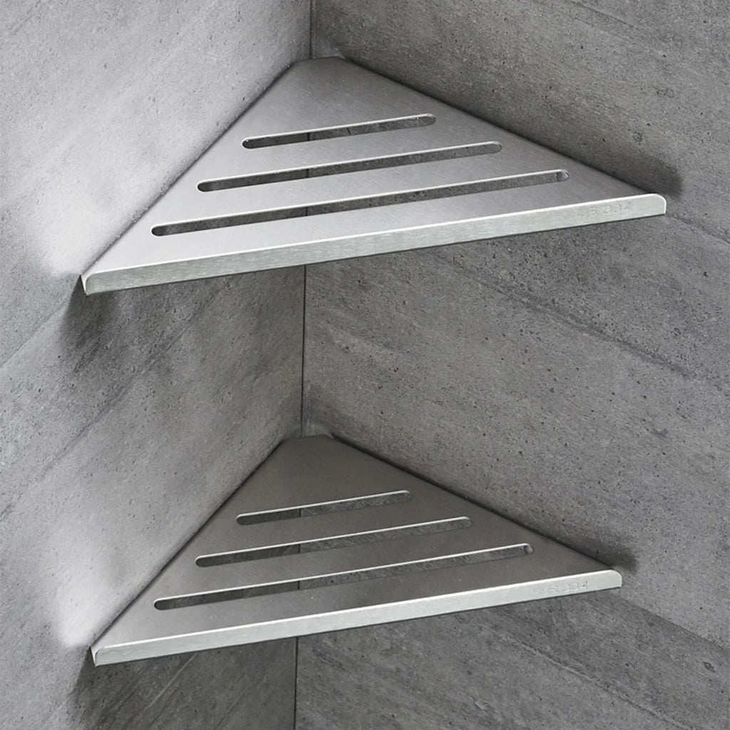 two stainless steel triangle corner shower shelves mounted in a tiled bathroom corner