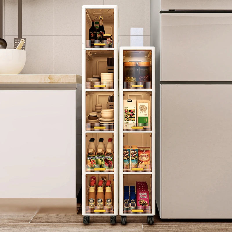 Two narrow rolling storage cabinets in a kitchen setting, placed between a cabinet and fridge, storing beverages and canned goods