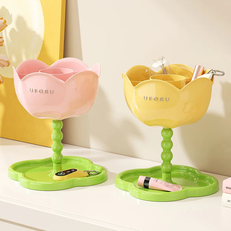 Pink and yellow flower-shaped organizer stands with green trays displayed on a white console, holding keys and accessories