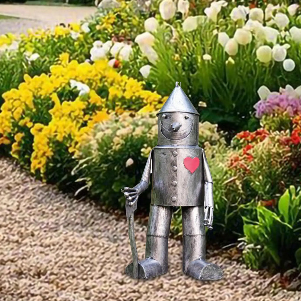 whimsical resin tin man garden ornament near blooming flowers