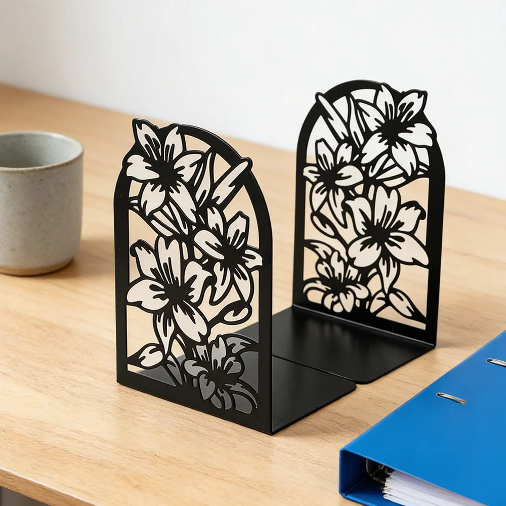 Two floral metal bookends on a wooden desk with a mug and blue folder in view