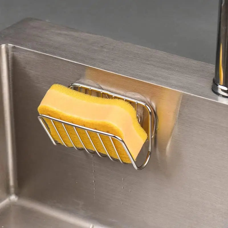 Stainless steel sponge holder in use holding a yellow sponge inside a kitchen sink