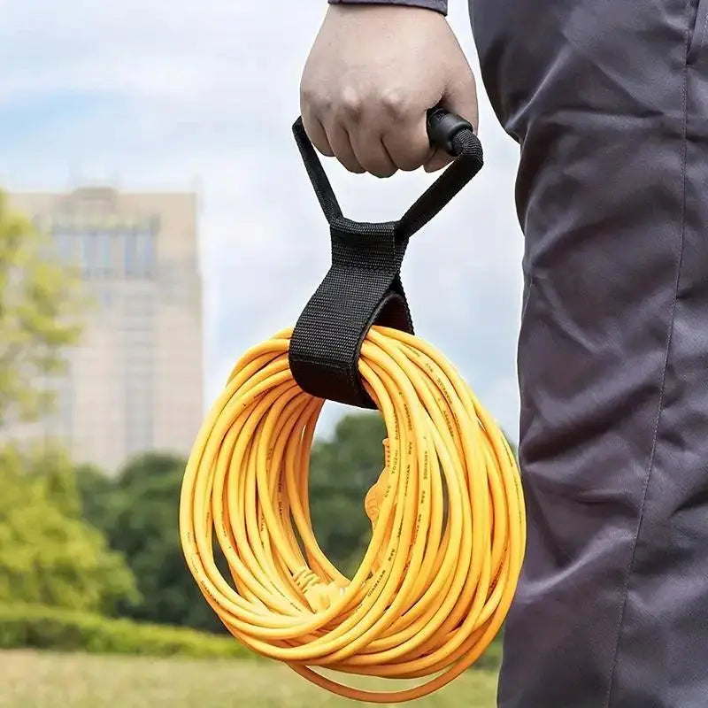 Person carrying a heavy-duty cord organizer strap with yellow extension cord outdoors