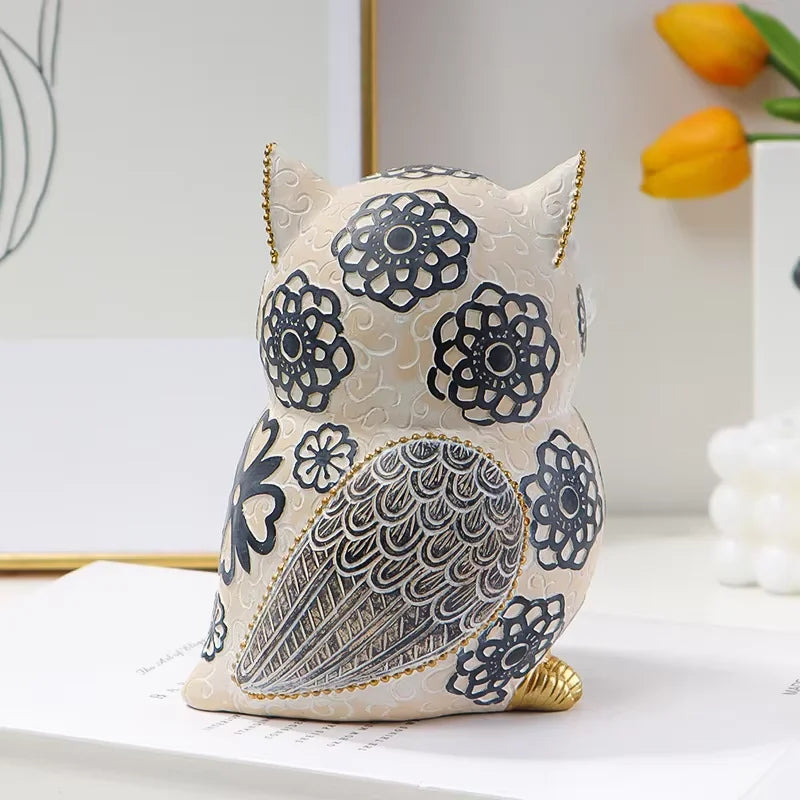 back view of owl resin figurine showing dark floral pattern and gold accents