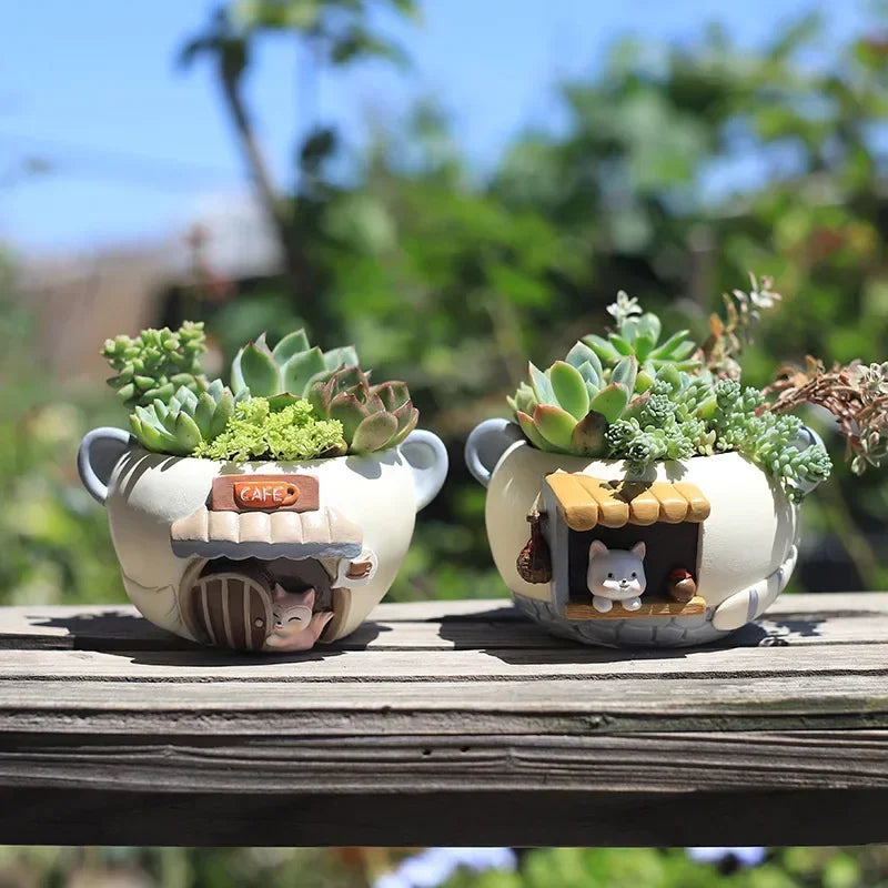Kitten and fox animal resin planters with succulents outdoors on a wooden rail