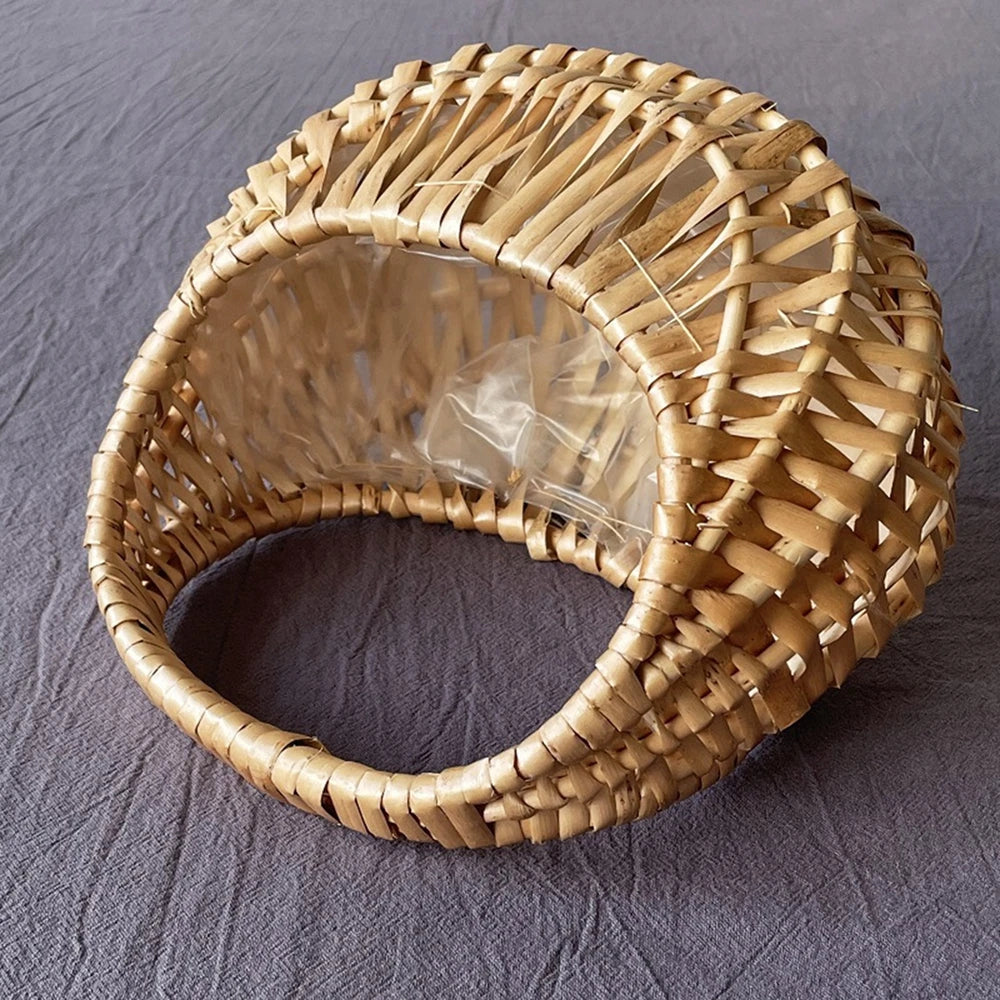 Empty woven rattan basket with clear plastic liner and moon shape