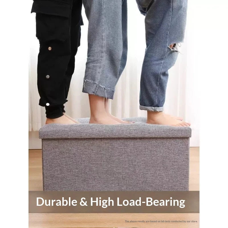 Two people standing on a rectangular linen storage ottoman to show load-bearing feature