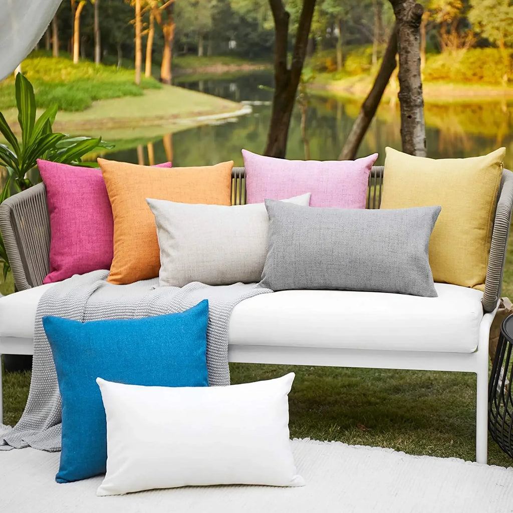 Solid color waterproof cushion covers arranged on an outdoor sofa with garden background