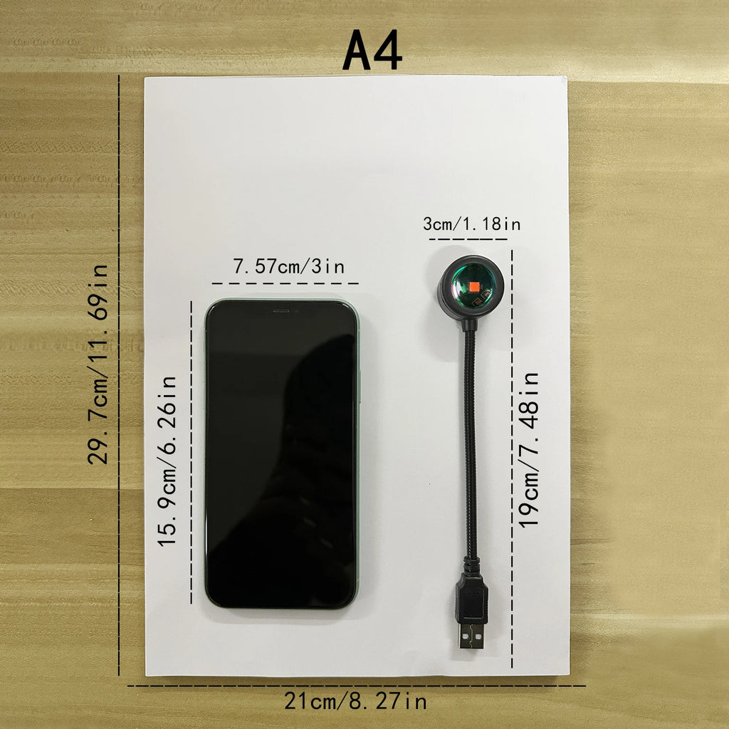 size comparison showing sunset projection lamp and a smartphone on A4 paper with dimensions