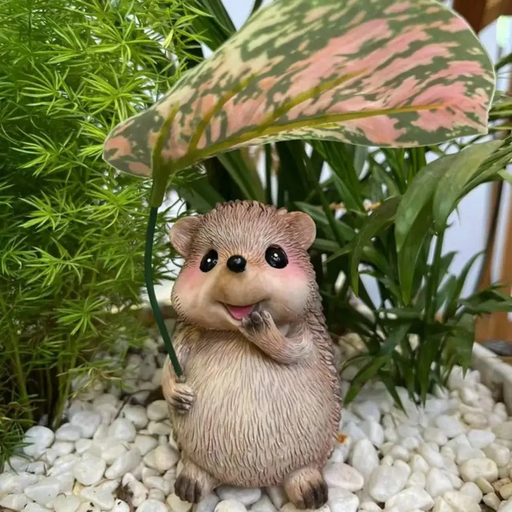 cute hedgehog garden statue nestled in white pebbles and greenery