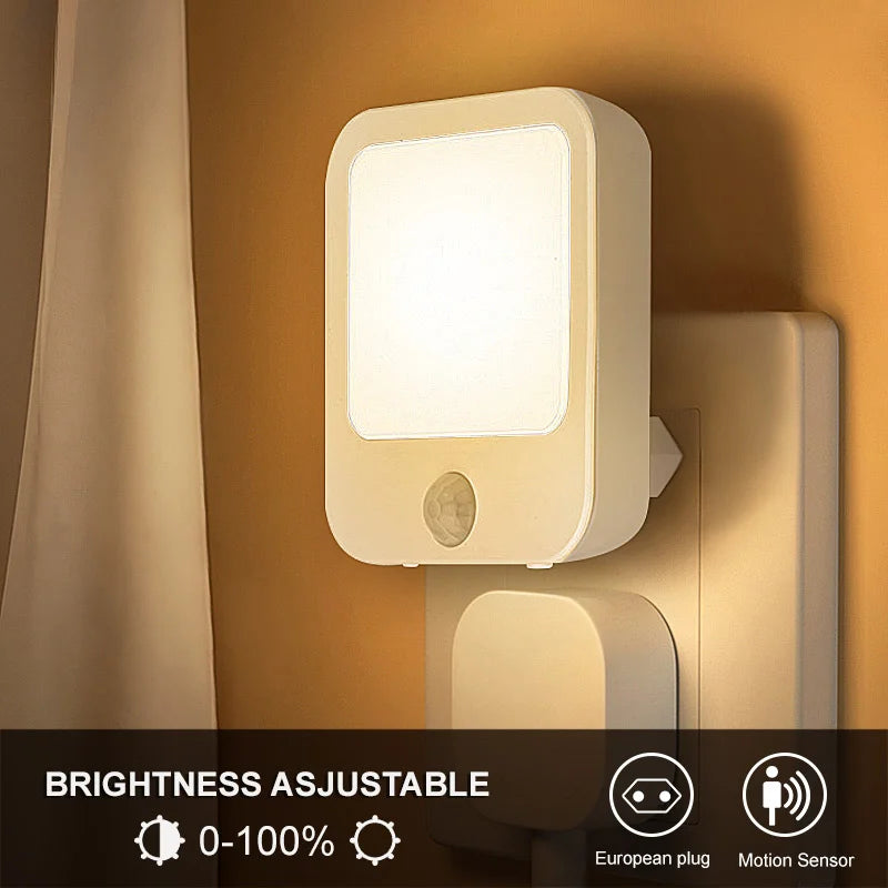 Plug-in motion sensor night light in a bedroom outlet, glowing softly against a wall