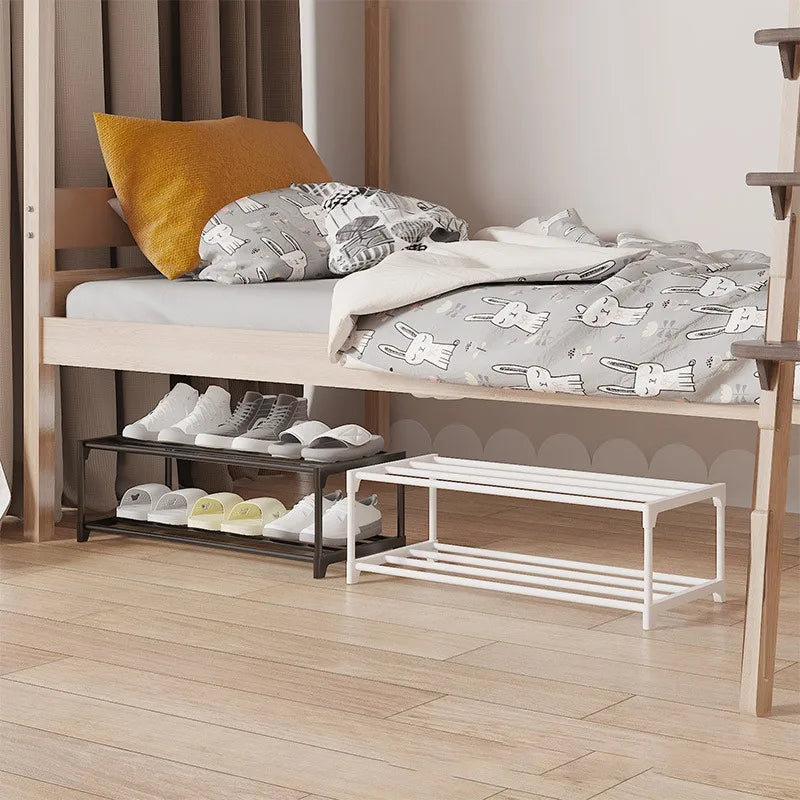 Black and white two-tier shoe racks placed under a child's bed, each holding several pairs of shoes