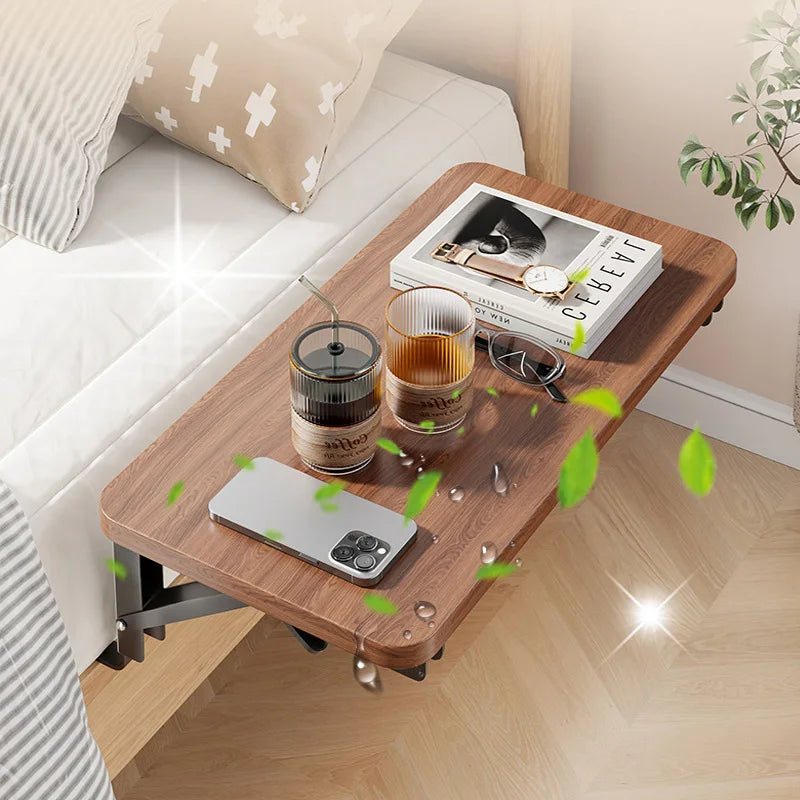Foldable bedside table shelf attached to bed, holding books, drinks, phone and glasses