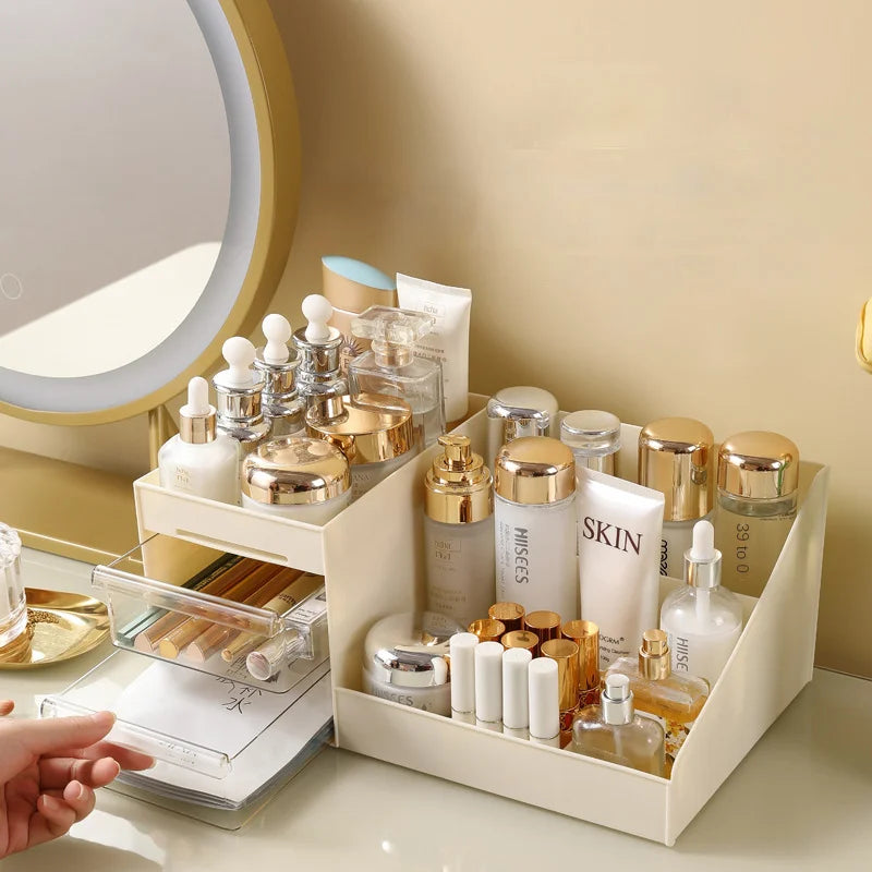 Beige makeup organizer with open compartments and clear drawers on a vanity