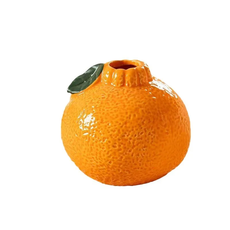 ceramic orange fruit-shaped vase on white background
