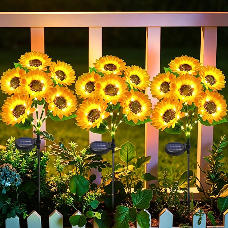 solar sunflower garden lights illuminating a garden flower bed at night