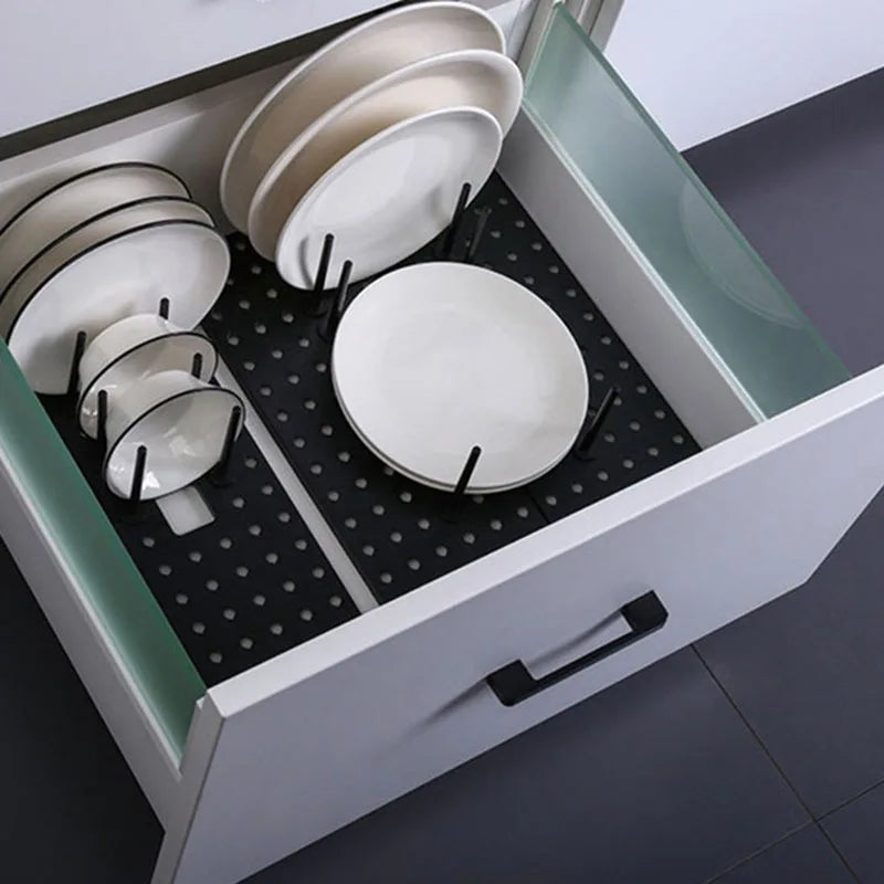 Adjustable light grey pegboard organizer with plates and bowls upright in kitchen drawer