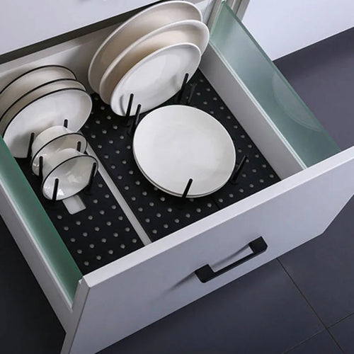 Adjustable light grey pegboard organizer with plates and bowls upright in kitchen drawer