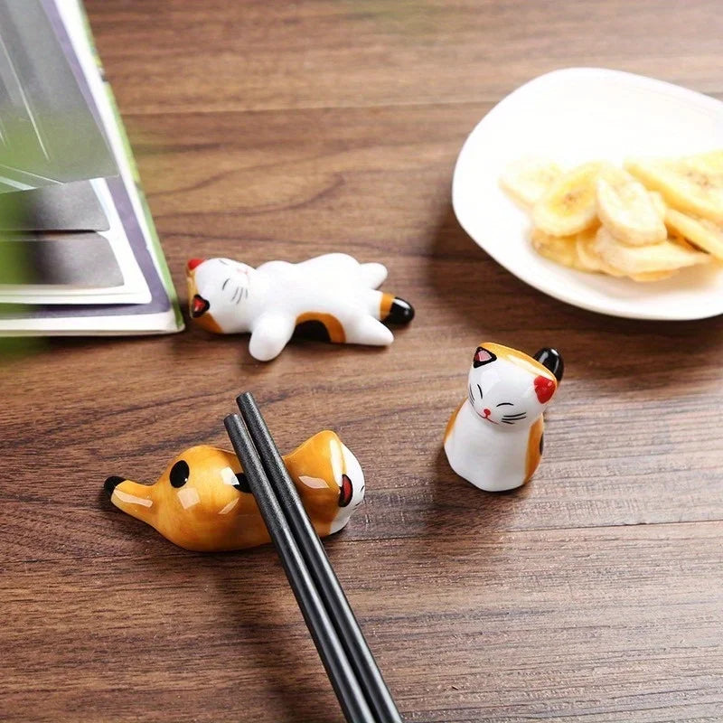 cat-shaped ceramic rests holding chopsticks on a wooden table