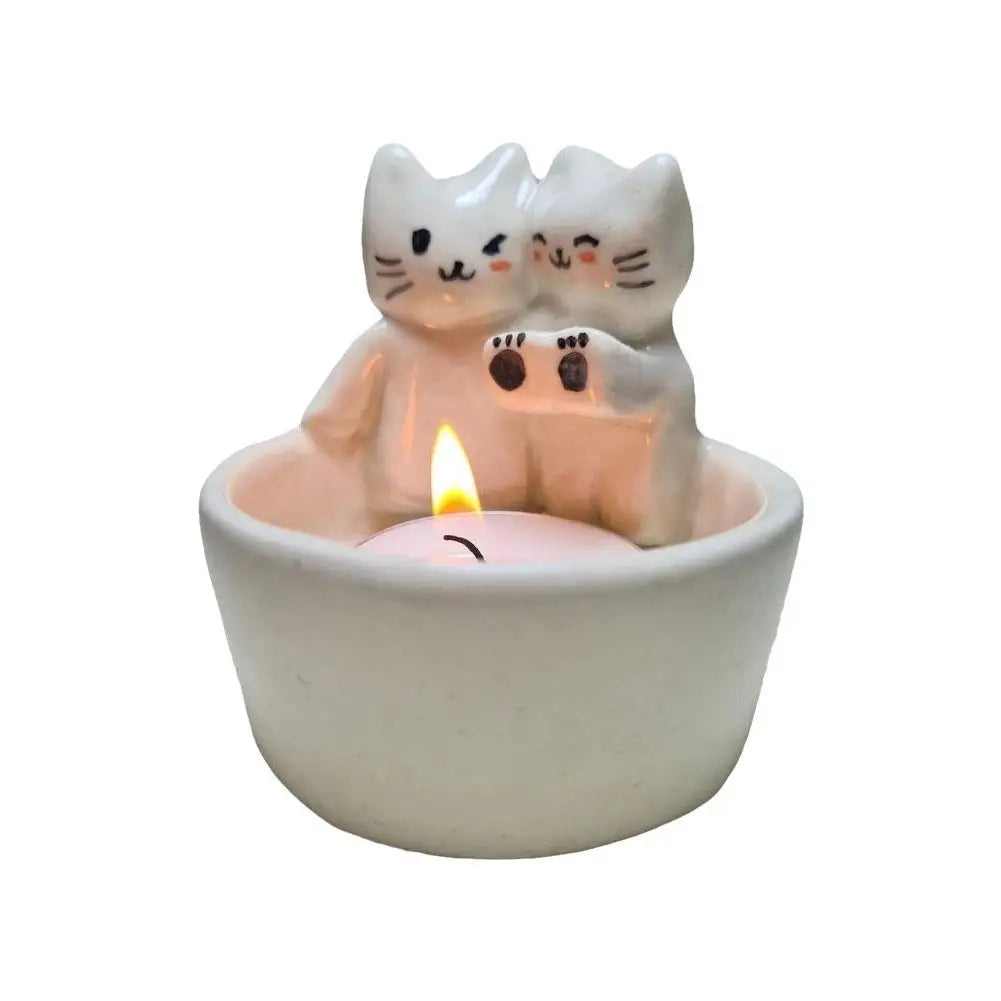 Front view of the cat tealight candle holder on white background with a lit tealight candle