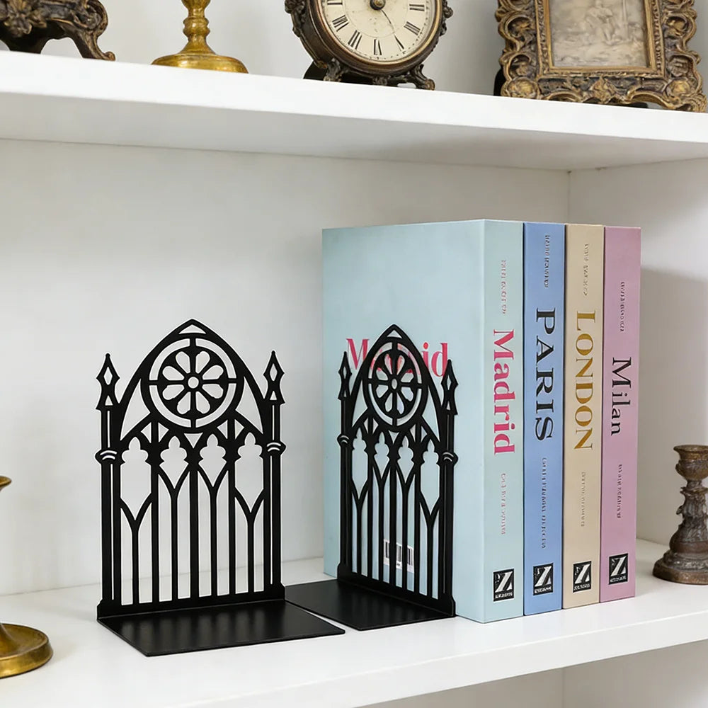 Gothic bookends supporting books on a white bookshelf with vintage decor